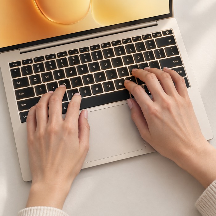 Hands typing on the keyboard and touchpad of the HONOR MagicBook 14 (2026) in Gold